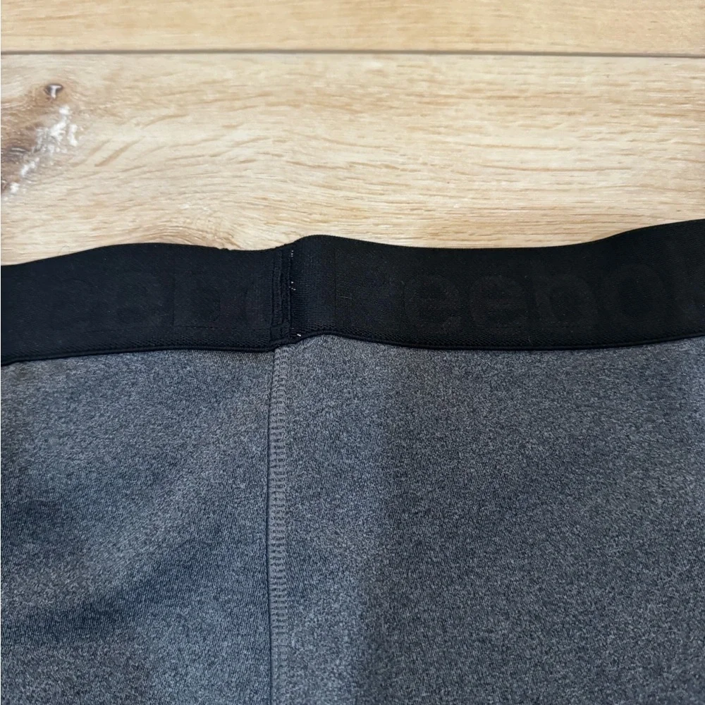 Reebok charcoal gray athletic leggings, mesh patterned detailing on side, S.
